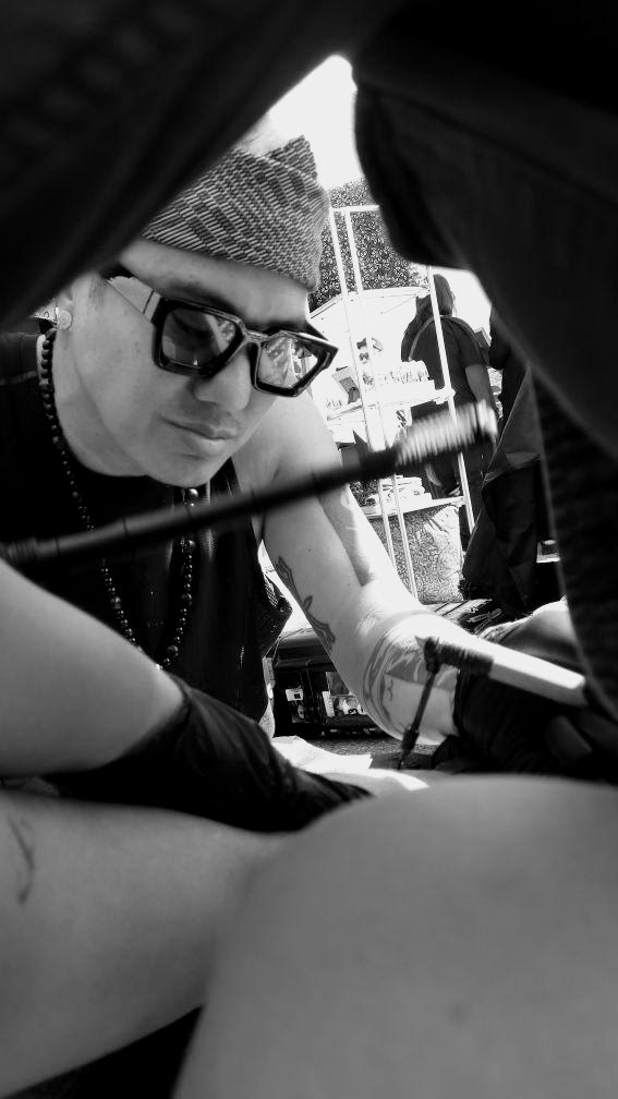 Kristian Kabuay practicing traditional hand-tap tattooing